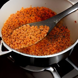 a pan full of cumin, coriander, onions, carrots, orange juice, vegetable broth and red lentils.