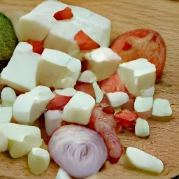the output is a large bowl of salad ingredients including tomatoes, cucumbers, red onions, feta cheese, olives and oregano that have been cut into various shapes and sizes.