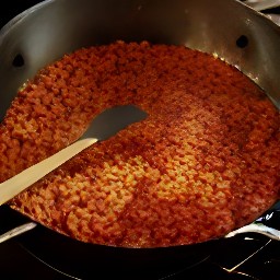 a dish of refried beans with chopped tomatoes.
