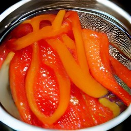 sliced peppers are drained from a jar in a sieve.