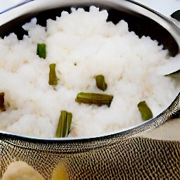 the rice and asparagus are drained in a sieve.