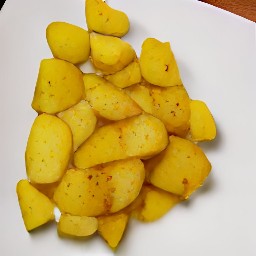 the potatoes are drained of extra oil and transferred to a plate.