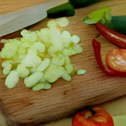 a peeled yellow onion cut into small pieces, a peeled tomato chopped into smaller pieces, and finely cut jalapeno peppers.