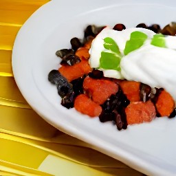a sweet and chili black bean dish topped with sour cream.