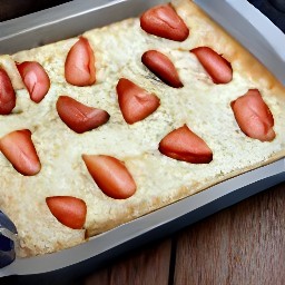 a baked pastry with feta cheese and sliced strawberries.