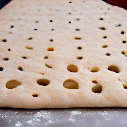 a rectangle dough with holes and olive oil on top.