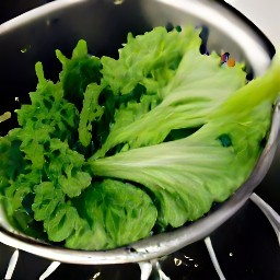 the lettuce leaves are drained in a colander.