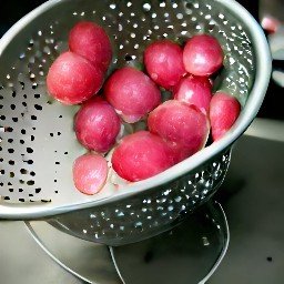 the radishes are drained of water in a colander.