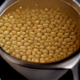 six tablespoons of chickpea water are reserved in a bowl.