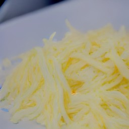 the grated mozzarella cheese is transferred to a plate.