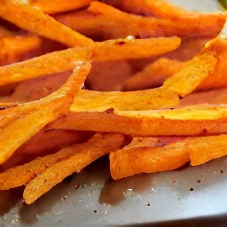 the sweet potato strips are transferred to the cookie sheet.