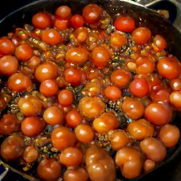 a dish of cherry tomatoes that have been cooked with garlic, onion, red wine vinegar, sugar, and crushed red bell peppers.