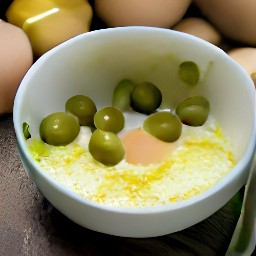 a bowl of eggs mixed with lemon zest, stuffed green olives, grated garlic and black pepper.