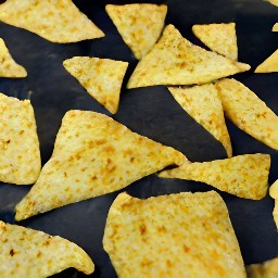 a cookie sheet with sliced corn tortillas sprinkled with salt.