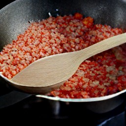 a pan of cooked tomatoes with onions, garlic, and breadcrumbs.
