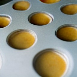 a muffin tin with the batter three-quarters full.
