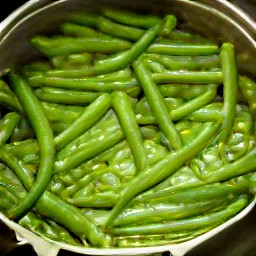 a pot of green beans with butter, onions, sour cream, and paprika.