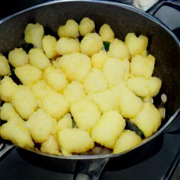a skillet full of onions and potatoes that have been cooked in butter for 3 minutes.