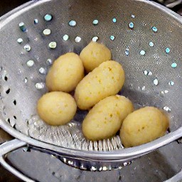 the potatoes are drained in a colander.