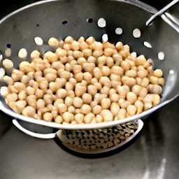 the canned chickpeas are drained in a colander.