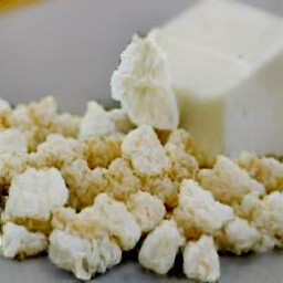 the feta cheese is crumbled using a wooden fork.