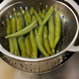 the green beans are rinsed and drained in a colander.