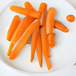 the roasted carrots are transferred to a serving plate.