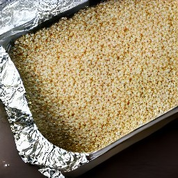 the quinoa is spread out on a baking sheet, drizzled with olive oil, and set aside to cool.