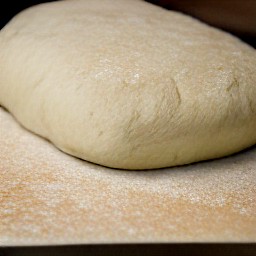 a baking sheet with cooking spray and bread dough on it.