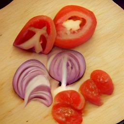 two sprigs of sage, halved tomatoes, halved red bell peppers, and quartered red onion.