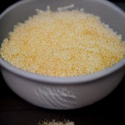 a bowl containing a mixture of mozzarella cheese, parmesan cheese, ground nutmeg, ricotta cheese, beaten eggs, chopped basil, dried parsley and garlic powder.