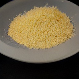the grated parmesan cheese is transferred to a plate.