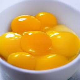 two more eggs cracked into a bowl, with the egg yolks added and whisked.