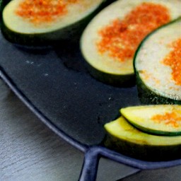 the zucchini and summer squash are flipped over using tongs, and the sauce is drizzled on top.