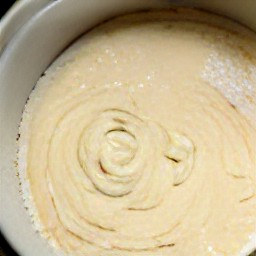 a bowl containing a batter made of 2 cups of granulated sugar, eggs, corn oil, whole milk, 1 tsp vanilla extract, lemon juice, all-purpose flour, coconuts and baking powder.