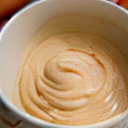 a bowl of batter containing all-purpose flour, baking soda, ground cinnamon, ground nutmeg, grated carrots, chopped walnuts, egg mixture and raisins.