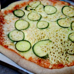 a pizza with dough, veggies, and cheese.