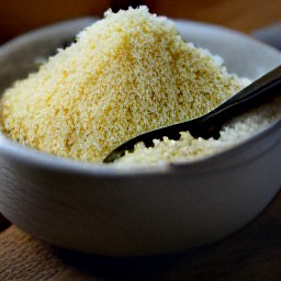 a bowl of grated parmesan cheese mixed with garlic powder, onion powder, paprika, dried thyme, dried rosemary, salt and black pepper.