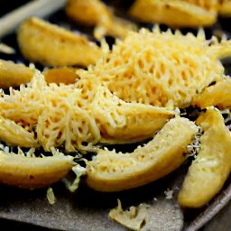 the potato wedges are skin-side down on a baking sheet with the seasoning mixture and olive oil.