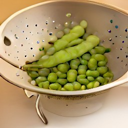 the edamame pods are rinsed and drained in a colander.