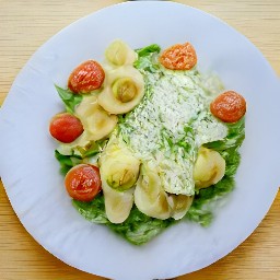 a caesar salad with tortellini pasta, tomatoes, and croutons.