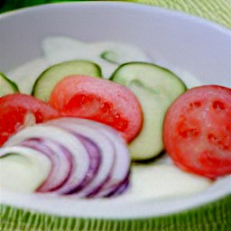 the salad will have a creamy dressing with tomatoes and cucumbers mixed in.