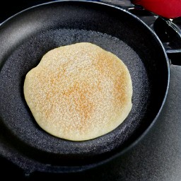 the pancake is now flipped over and can continue to cook on the other side.