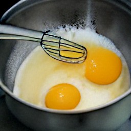 a bowl of egg yolks, salt, pepper, and whipping cream that have been combined.