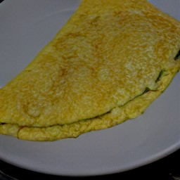 the cheese omelet is transferred to a plate.