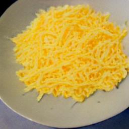 the grated cheddar cheese is transferred to a plate.
