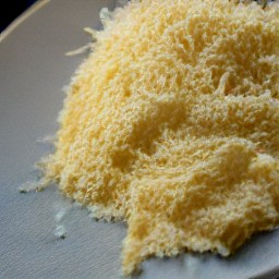 the grated parmesan cheese is transferred to a plate.