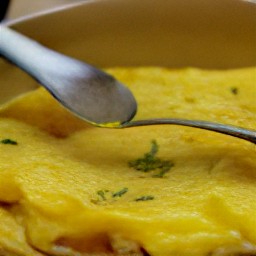 the omelet is folded in half with a spoon.