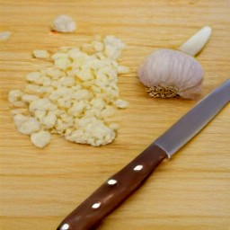 after peeling the onions, slice them with a knife. then, peel and chop the garlic.