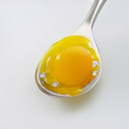 the egg white falls through the slotted spoon while the yolk stays in the spoon.